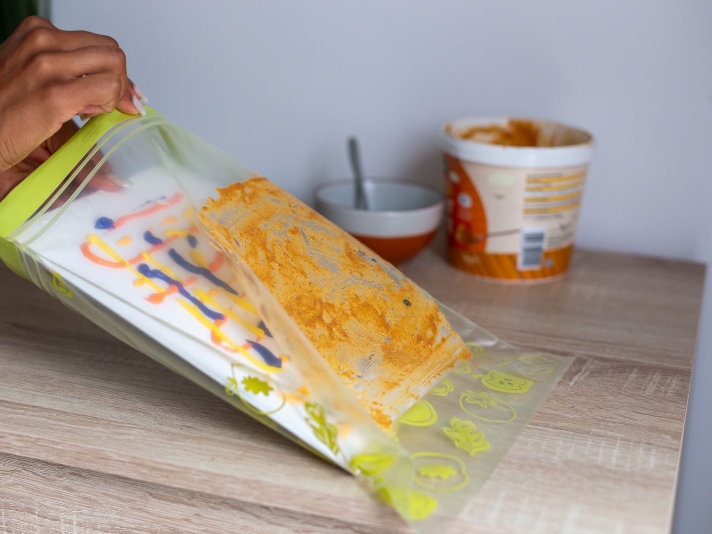 a white canvas with paint squiggled on it being put into a large sandwich bag